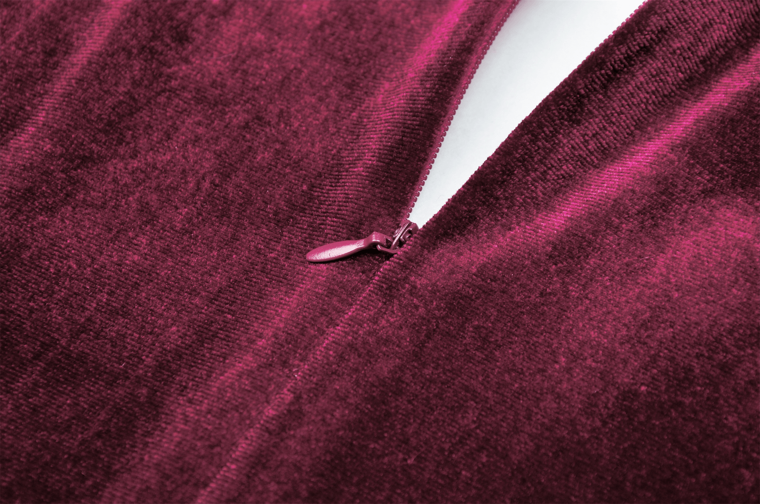Close-up of burgundy velvet dress zipper showcasing soft texture and rich color for a vintage-inspired look.