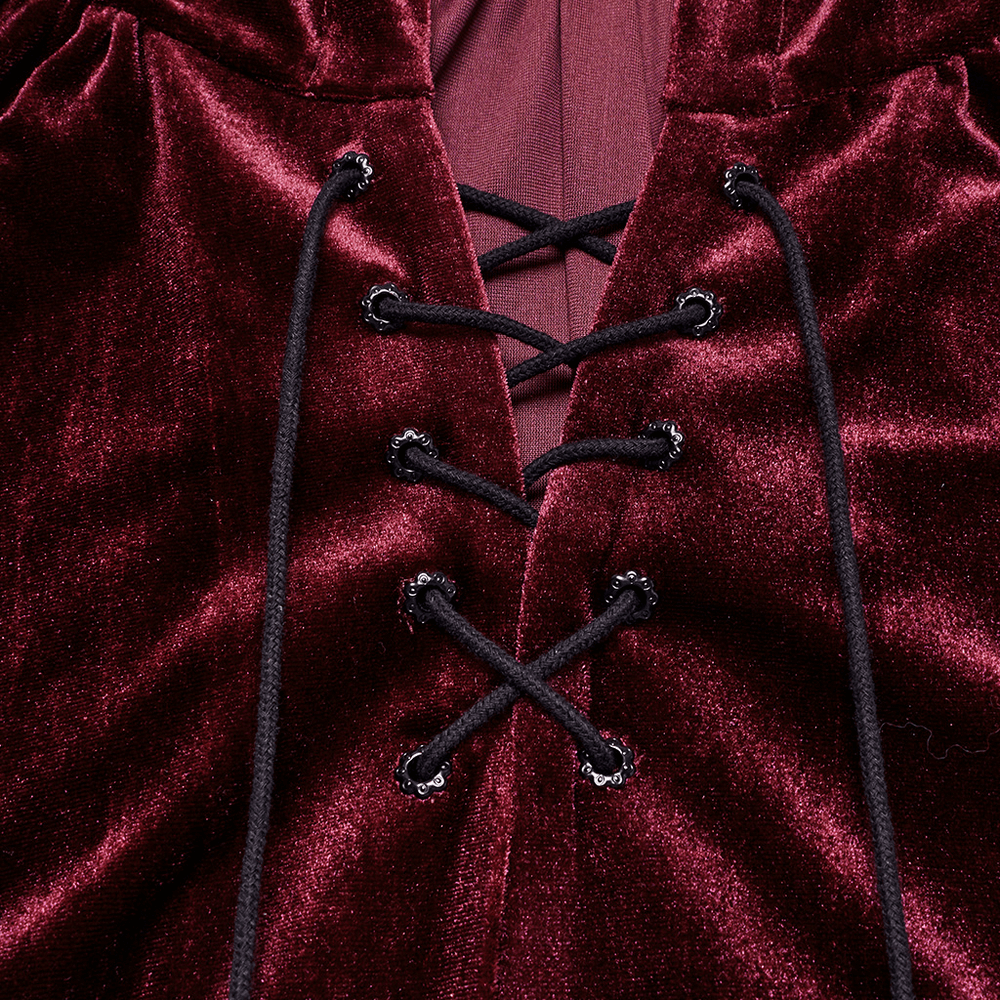 Close-up of burgundy velvet hooded cape with lace-up drawstring front and sleek minimalist design.