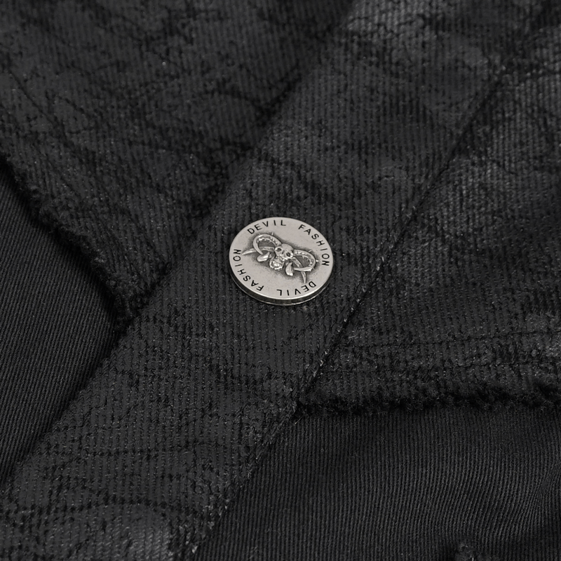 Close-up of metal button on a black sleeveless punk shirt, showcasing edgy design and alternative fashion flair.