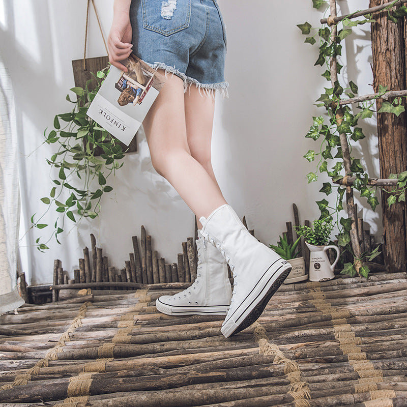 White lace-up mid-calf sneakers paired with denim shorts, embodying a stylish rock look in a trendy setting.