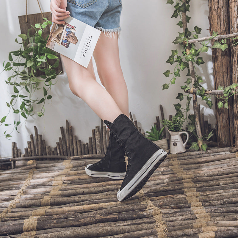 Stylish woman wearing black canvas lace-up mid calf sneakers for a trendy rock style look. Perfect for adding edge to any outfit!