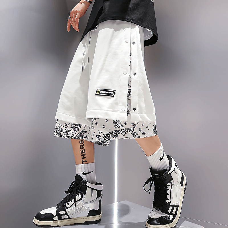 Men's punk style baggy shorts with drawstring, bold print, matched with stylish sneakers for edgy casual look.