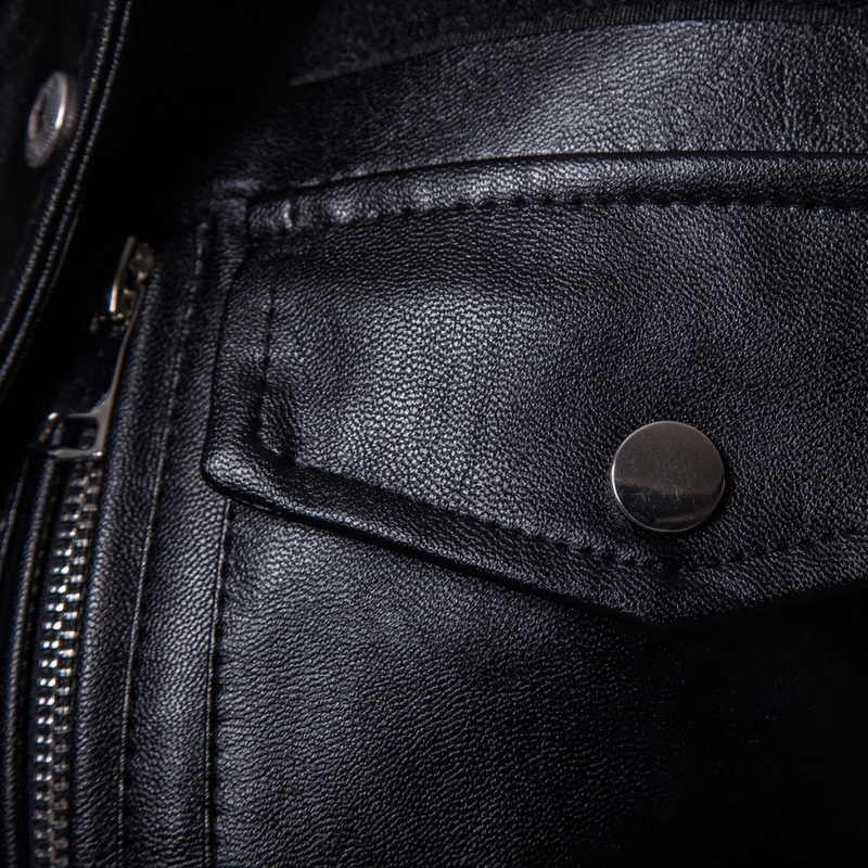 Close-up of a black PU leather biker coat with a silver zipper and button detail, showcasing the sleek texture and craftsmanship.