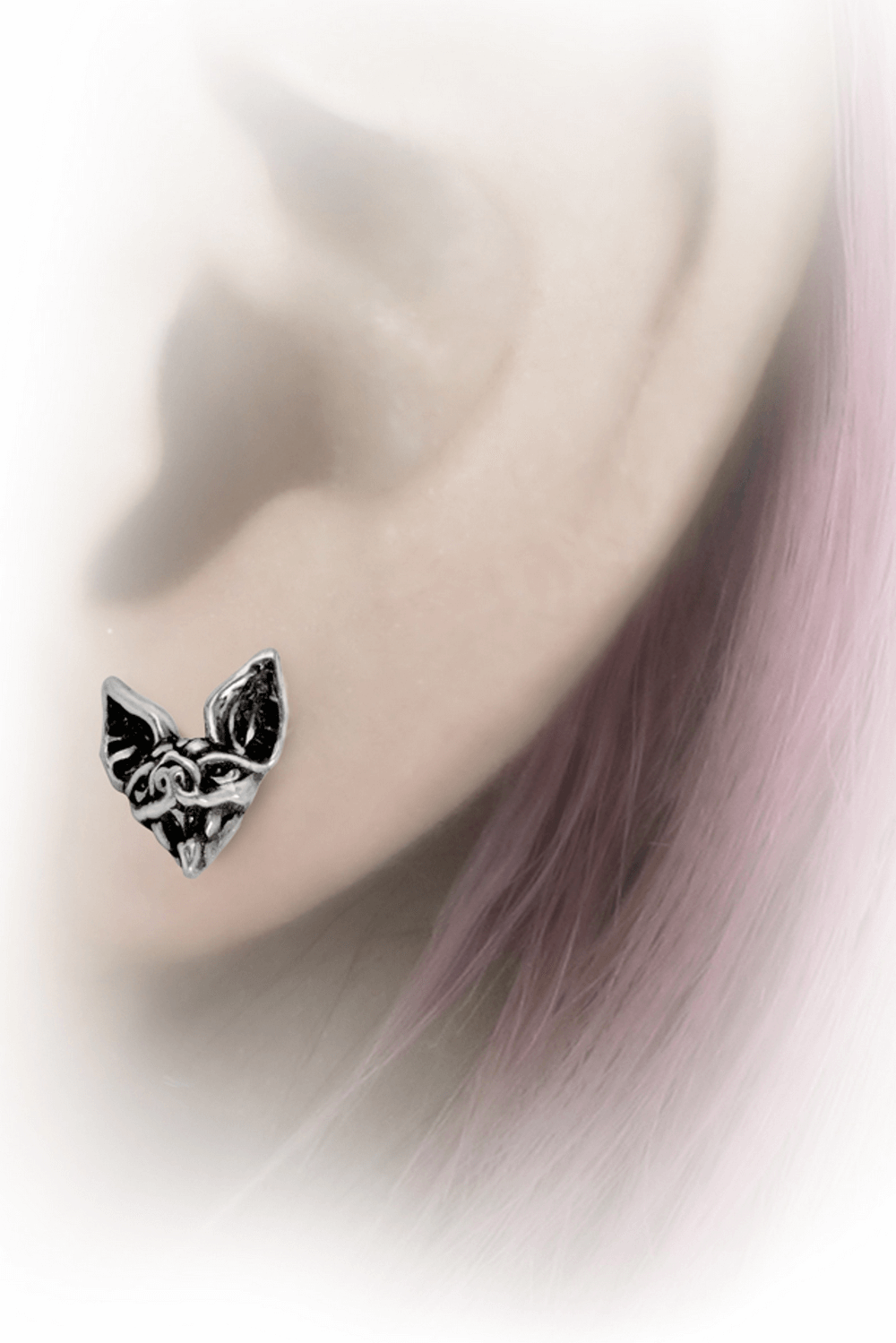 Intricate Cauchemar Bat Head Stud Earrings worn on a lobe, perfect for gothic and punk fashion lovers.