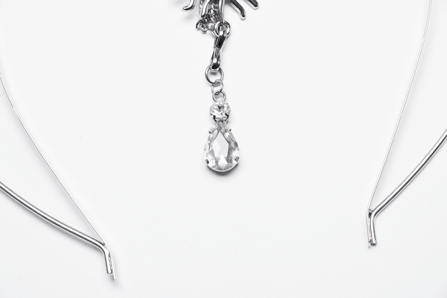Close-up of a crystal water droplet pendant on a celestial gothic headpiece with intricate details.