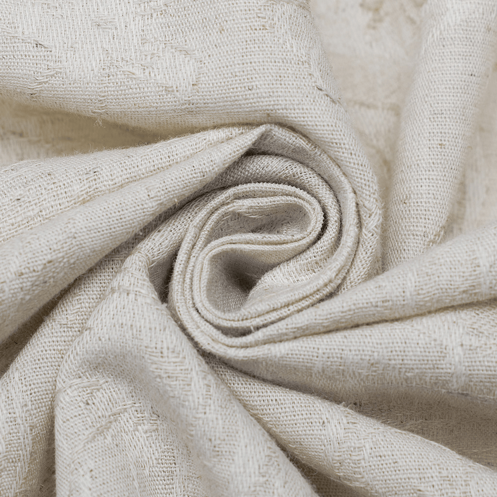Close-up of soft, cream-colored linen fabric, showcasing its textured weave and natural fibers.