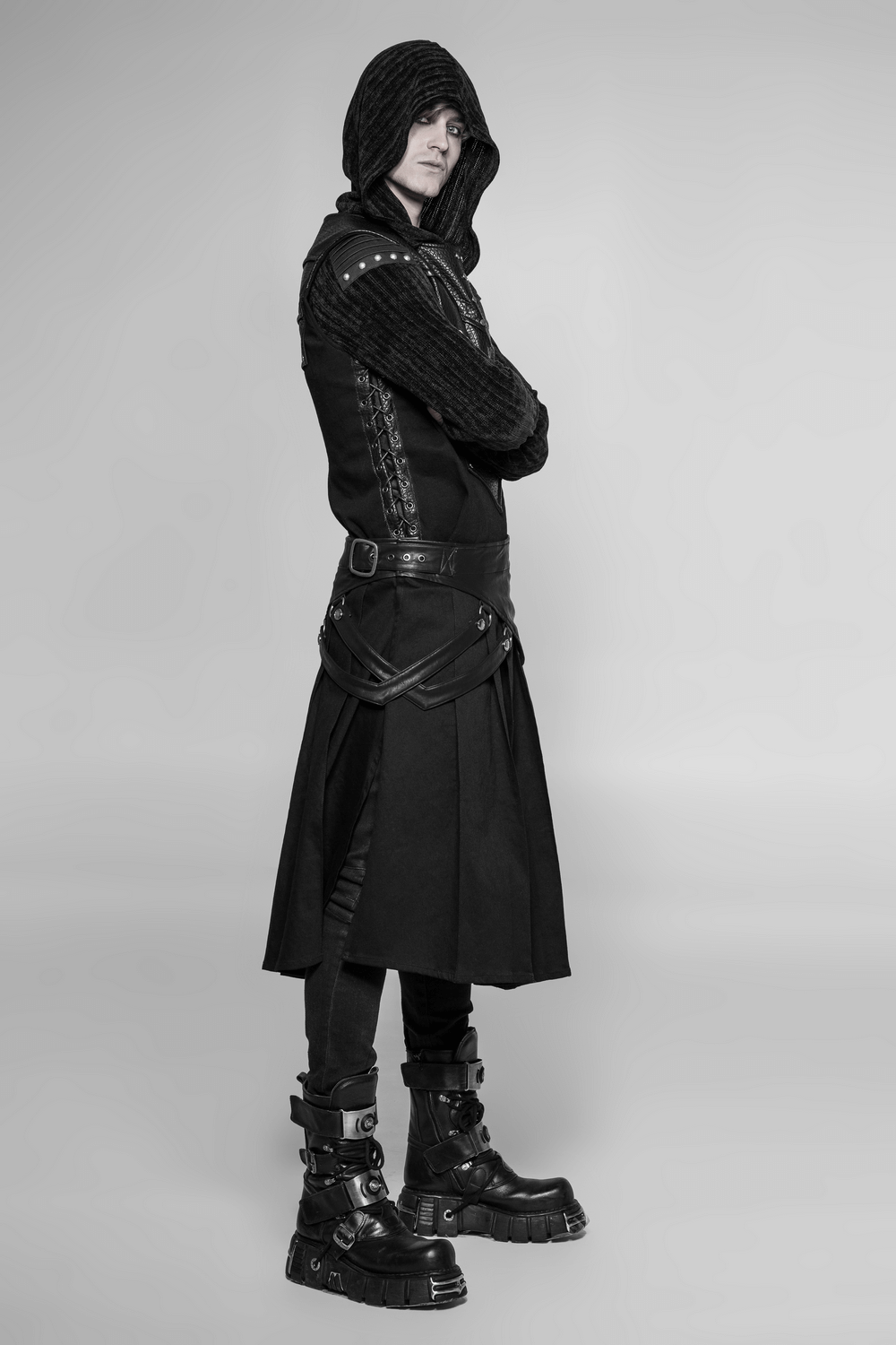 Stylish model wearing a black chest protector vest with adjustable lacing and edgy boots, showcasing a modern look.