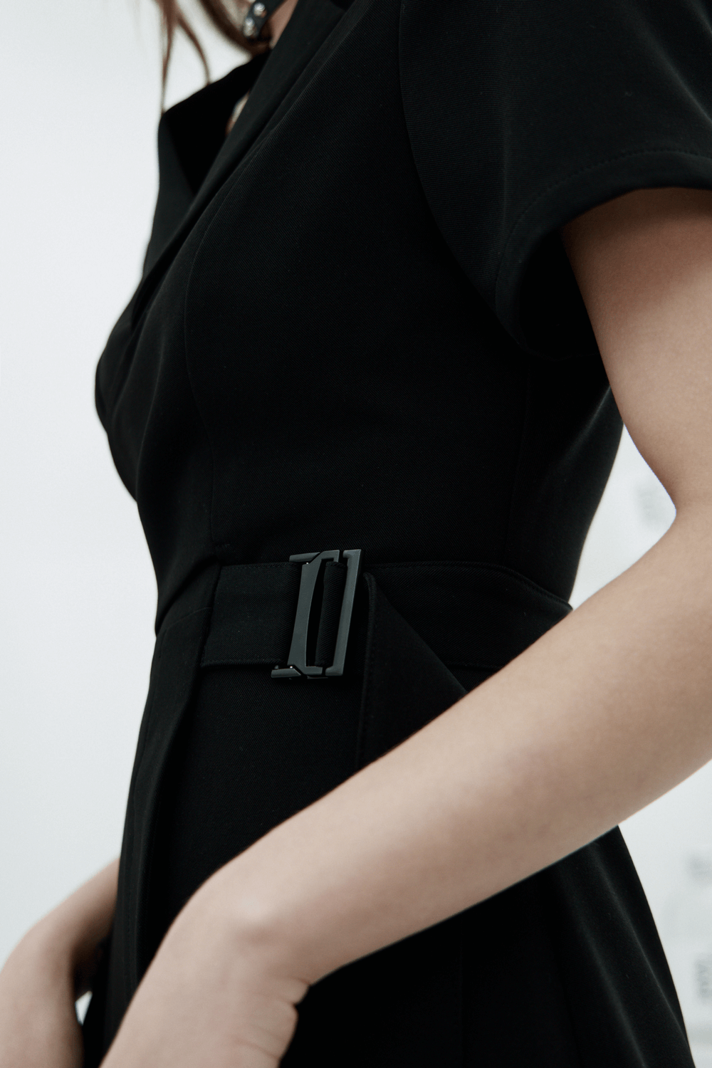 Close-up of a chic A-Line dress featuring a stylish buckle detail and elegant suit collar design.