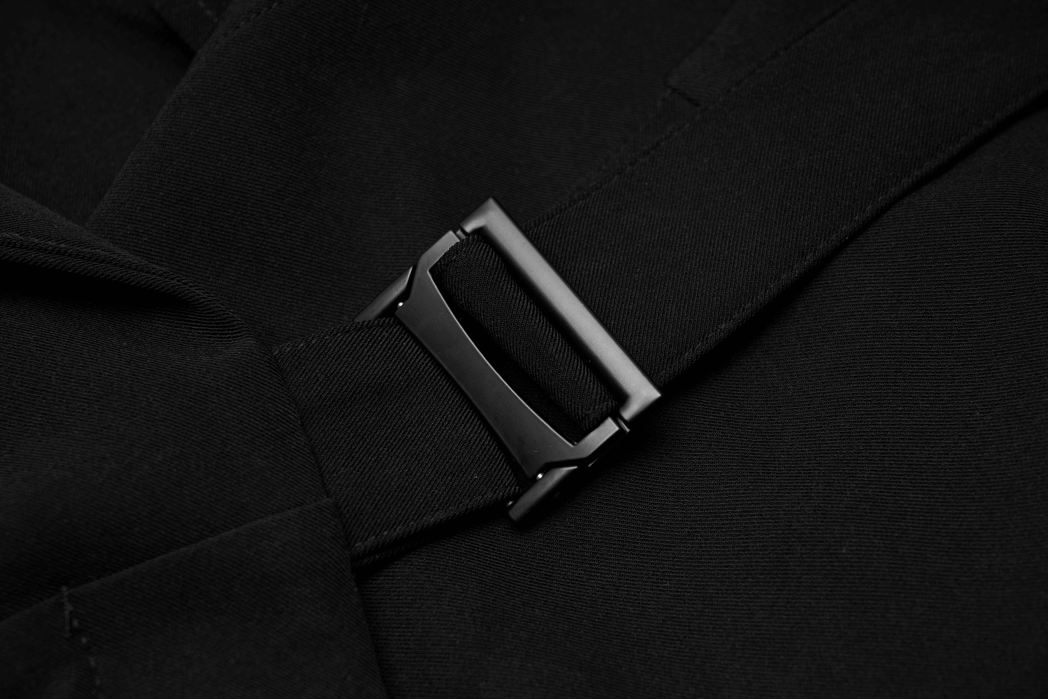 Close-up of a stylish black buckle detail on a chic dress, showcasing elegant design features.