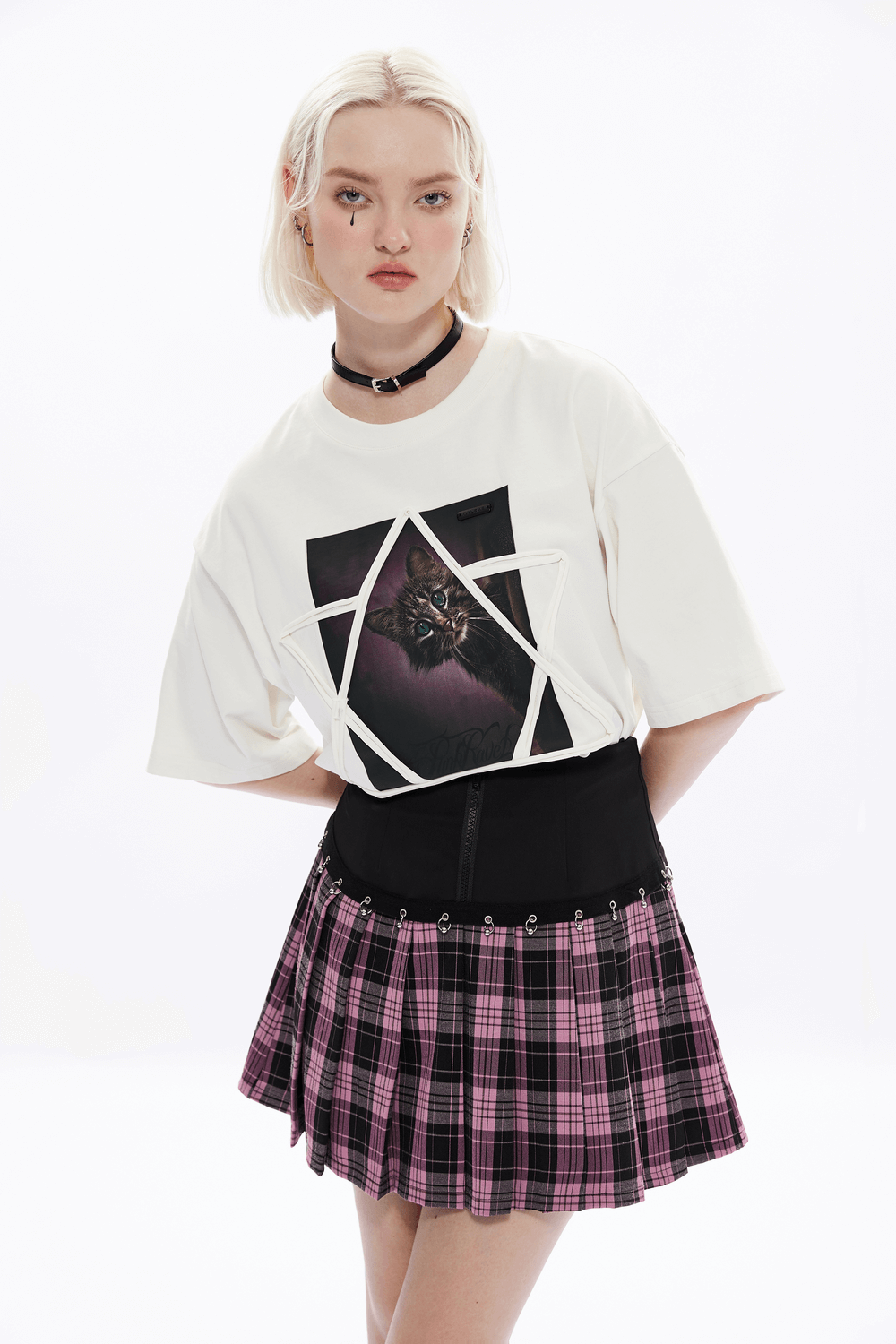 Model wearing a chic white graphic tee and a plaid A-line mini skirt with edgy details.