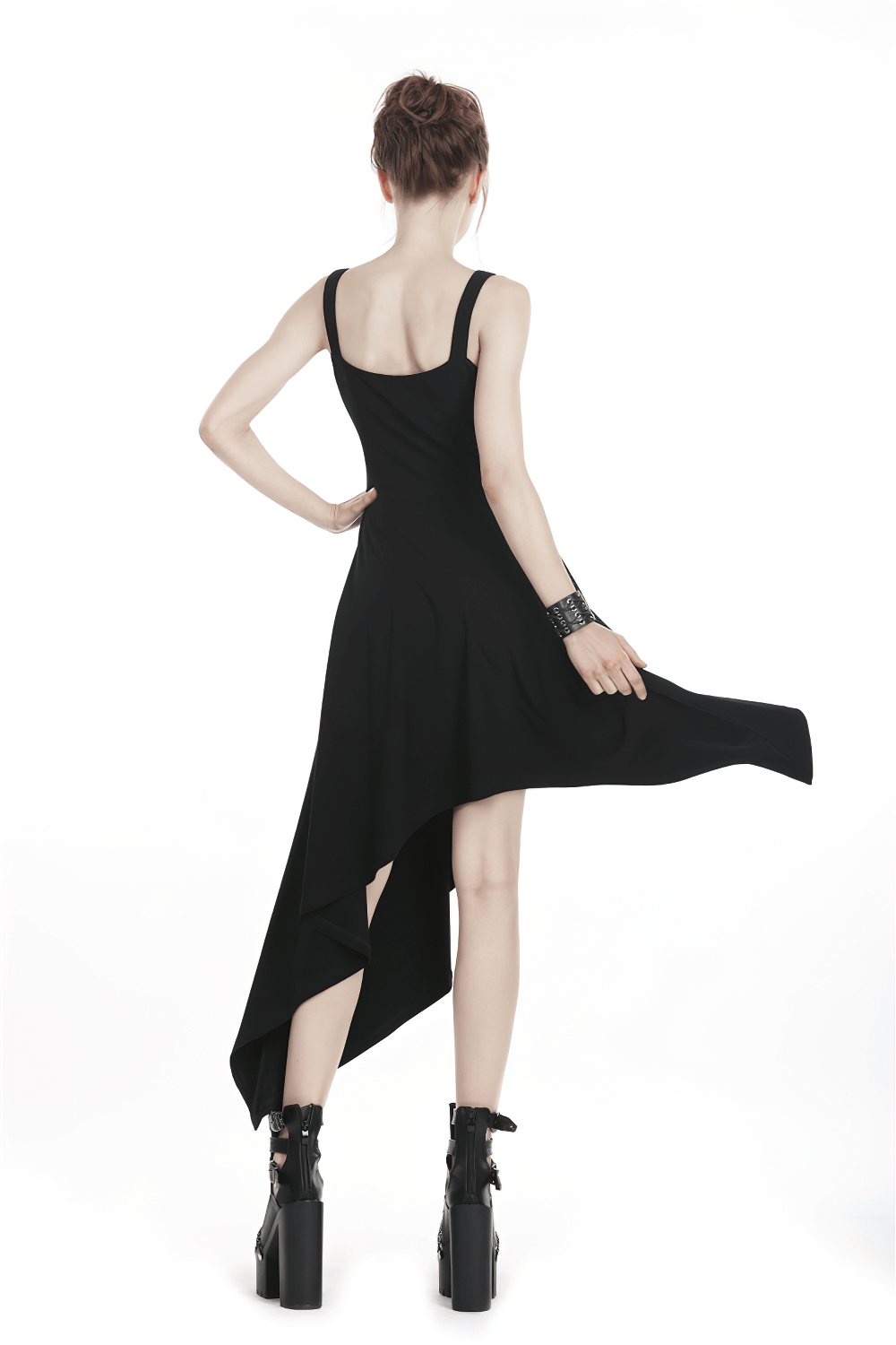 Fierce black asymmetrical dress with strap and chain detailing, showcasing elegant flow and edgy style from the back.