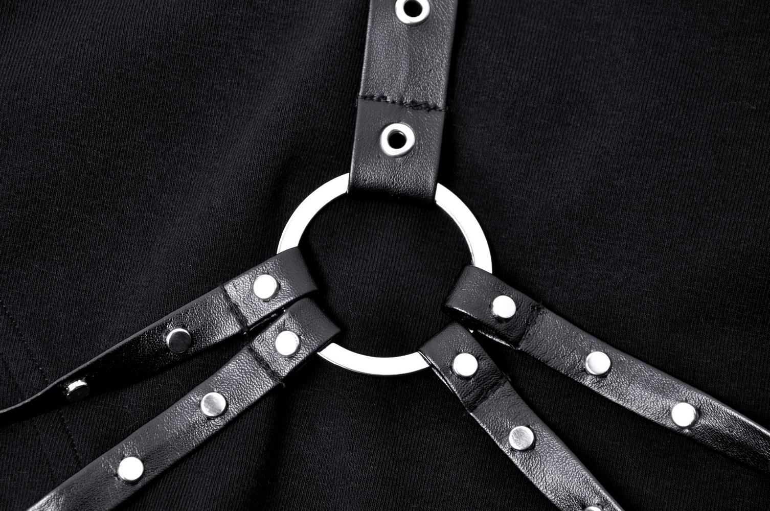 Close-up of black strap detailing with silver ring on stylish asymmetrical dress, showcasing edgy fashion elements.