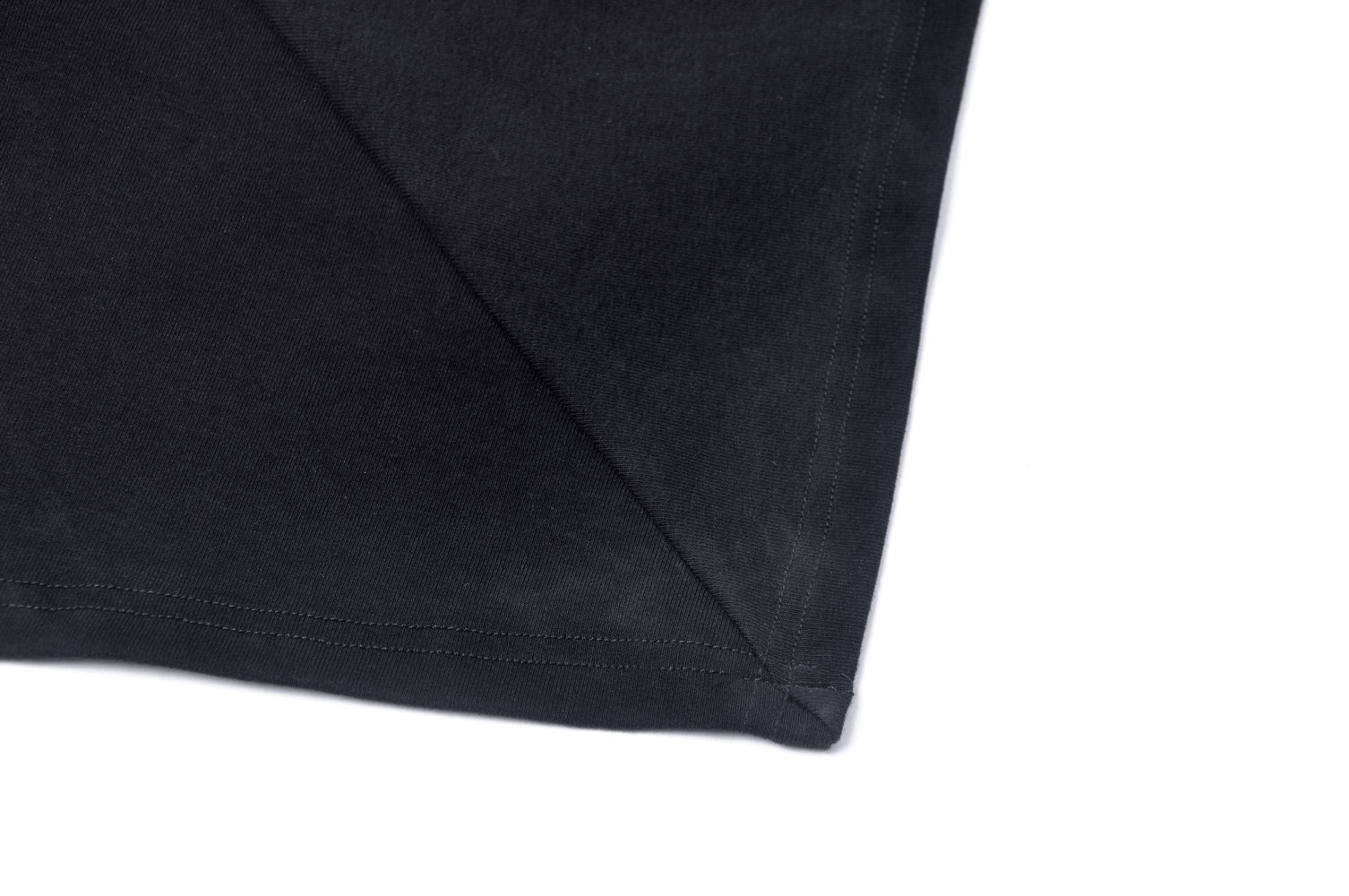 Close-up of black dress hem showcasing stylish asymmetrical design and high-quality stitching.