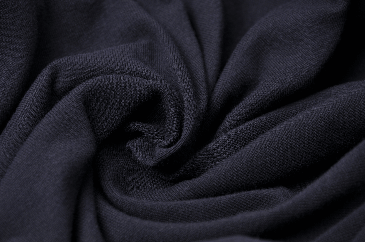 Close-up of soft black fabric showcasing luxurious texture and gentle stretch, perfect for an asymmetrical dress.