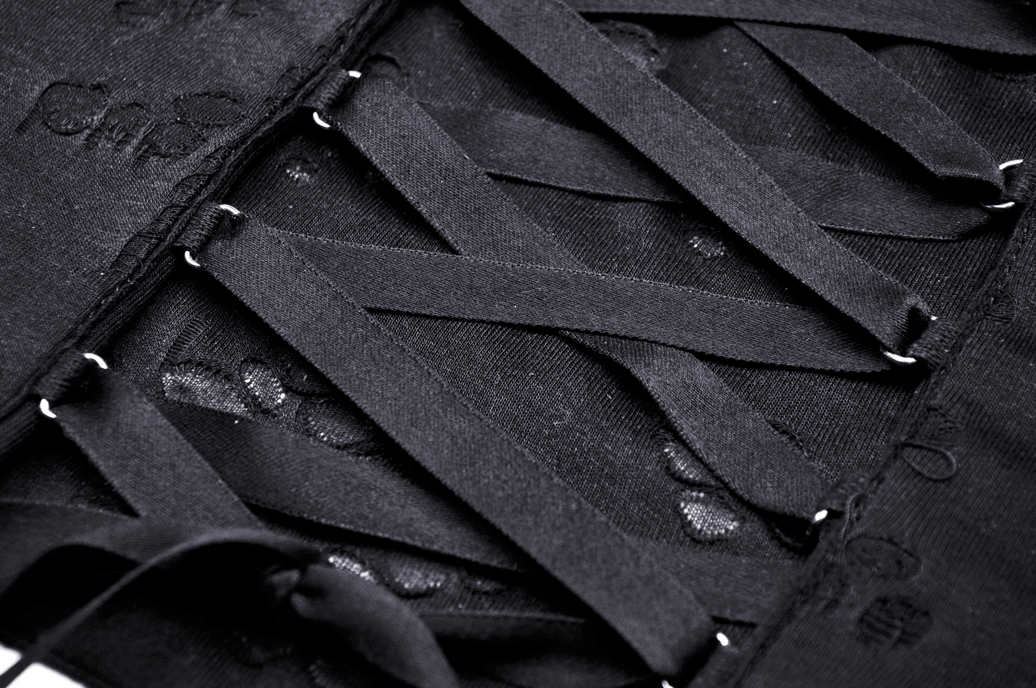 Close-up of lace-up back detailing on a chic black halter top, showcasing stylish straps and a modern aesthetic.