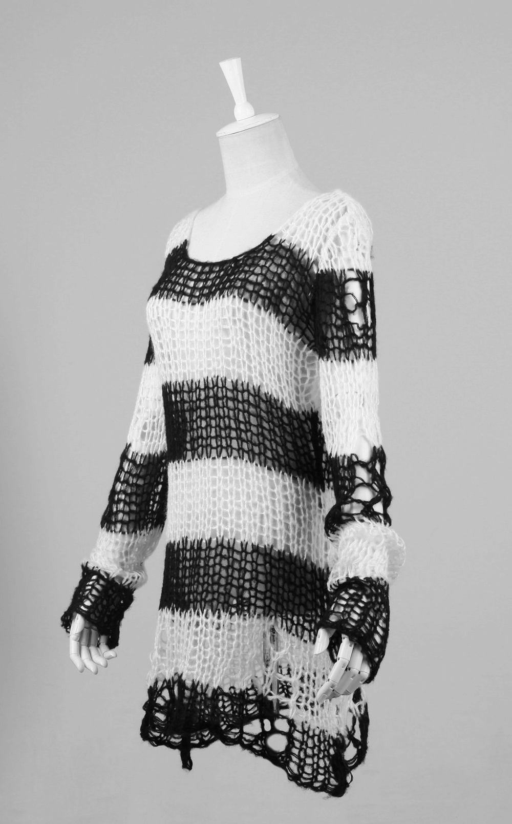 Chic black and white striped long sweater with holes, perfect for trendy fashionistas, showcasing a modern knit design.