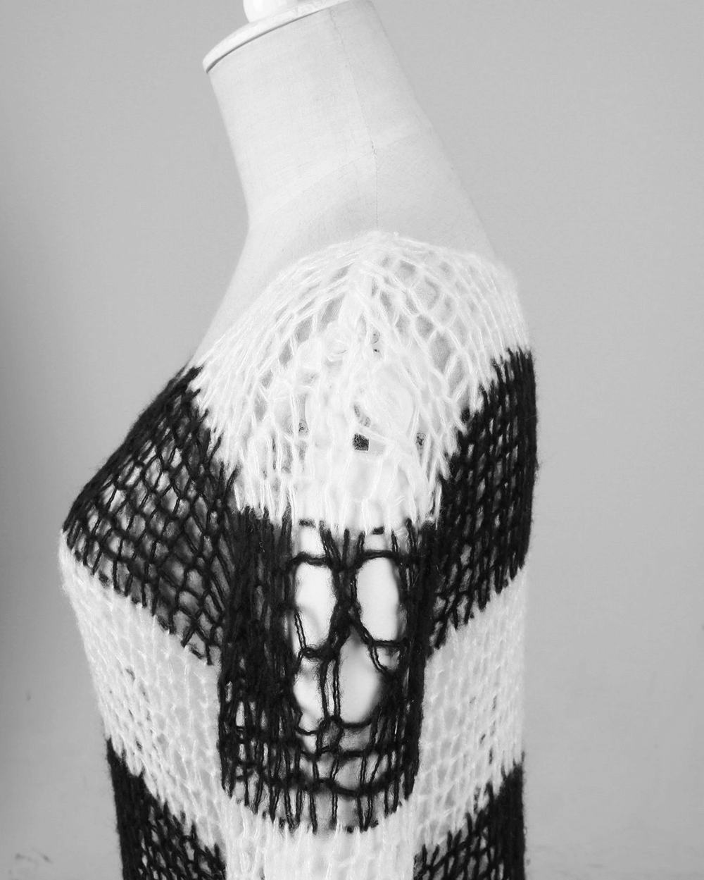 Chic black and white striped long sweater with unique knit pattern and holes, perfect for modern fashionistas.