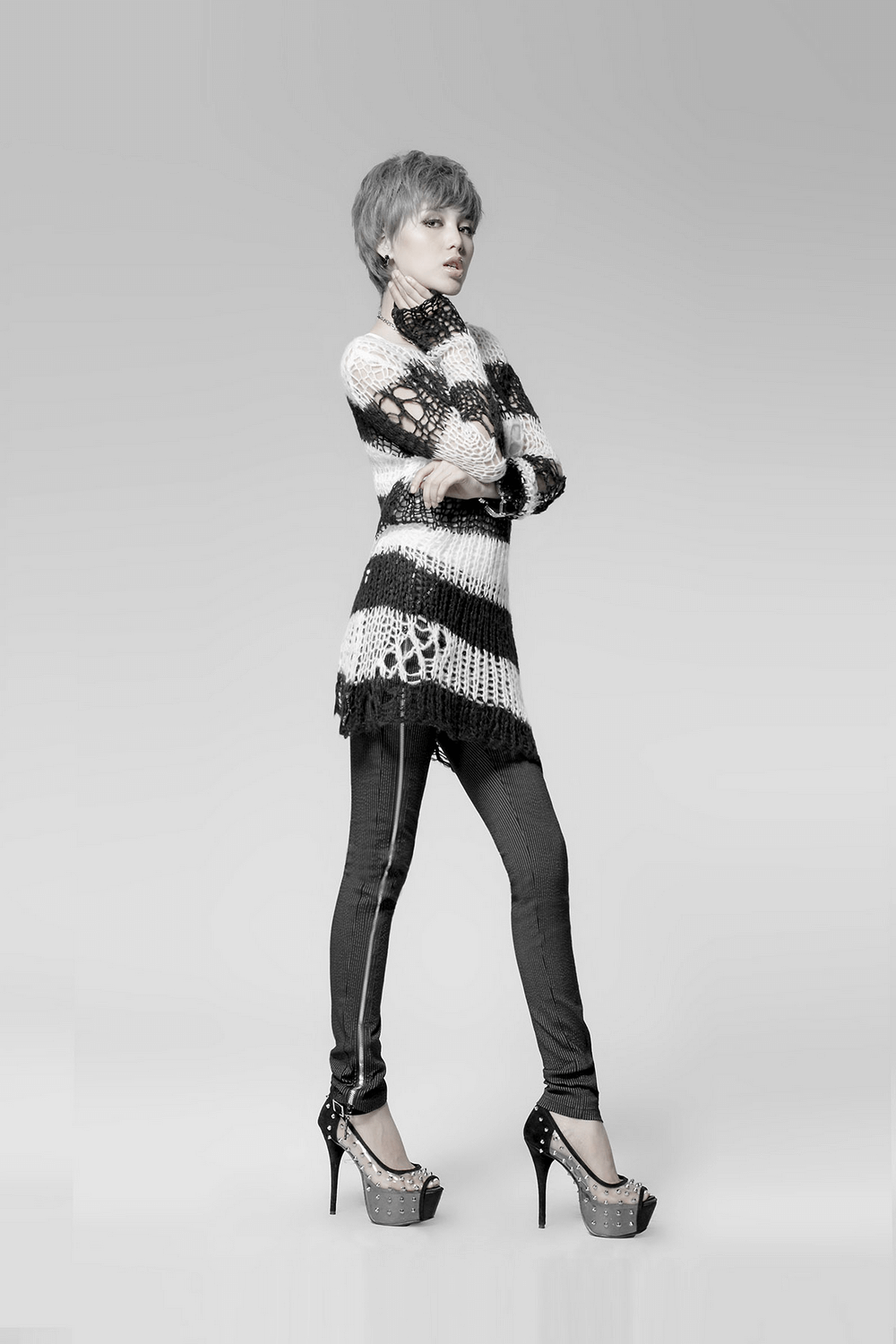Chic black and white striped long sweater with holes, styled for modern fashion enthusiasts.