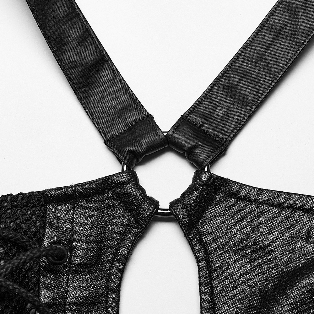 Close-up of chic black asymmetric top showing metal hoop and elegant eyelet details.