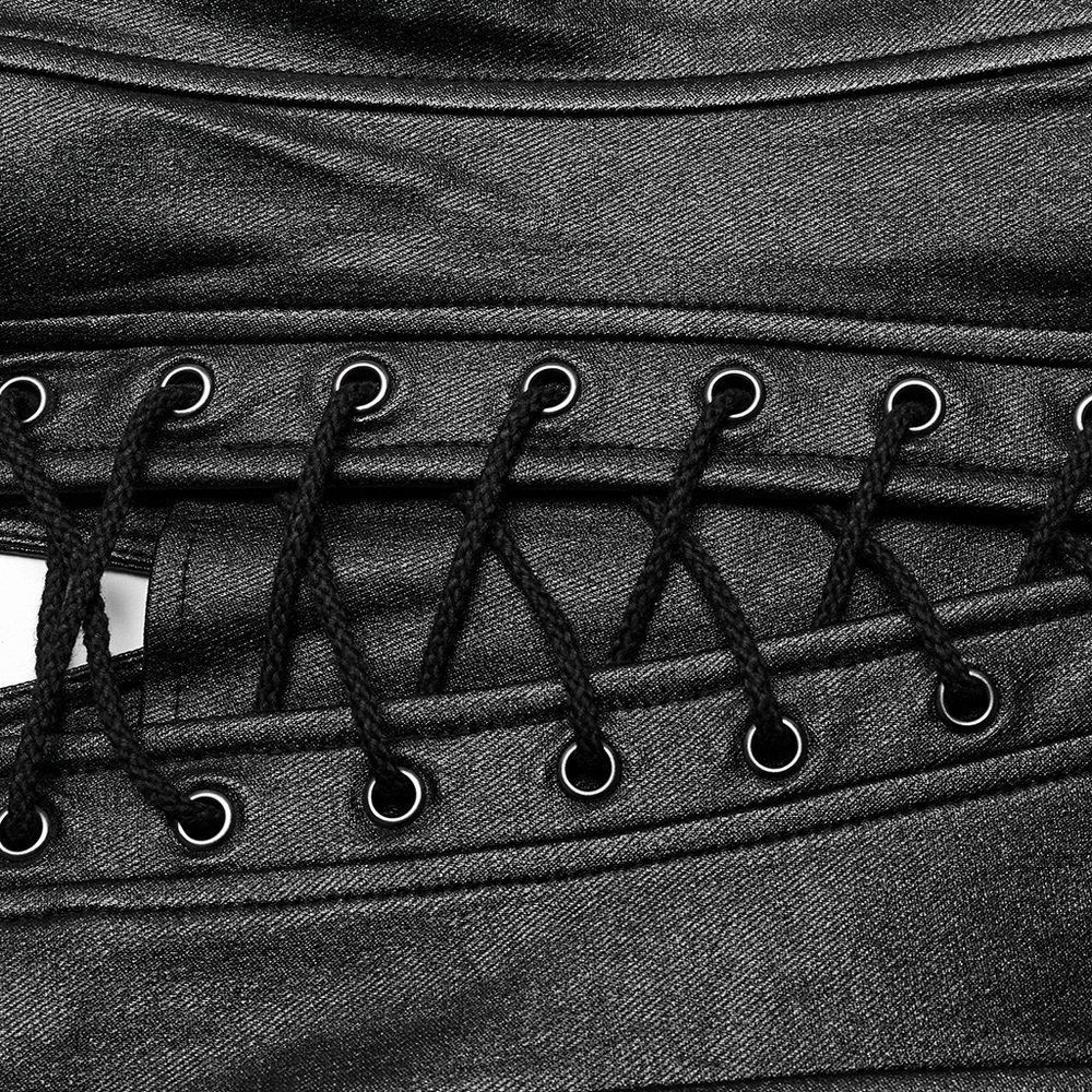 Close-up of black asymmetric top featuring eyelet details and lace-up design for a chic, edgy fashion statement.