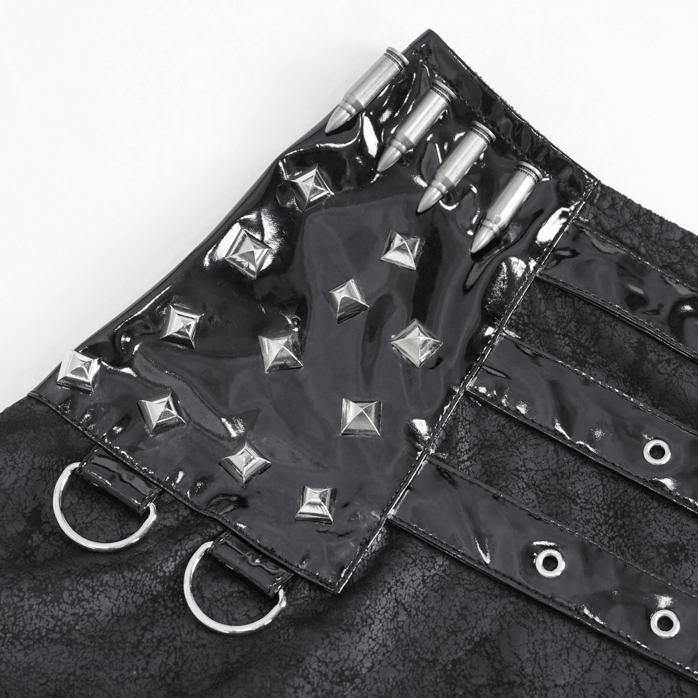 Close-up of gothic faux leather skirt detailing with silver buckles, studs, and edgy hardware accents.