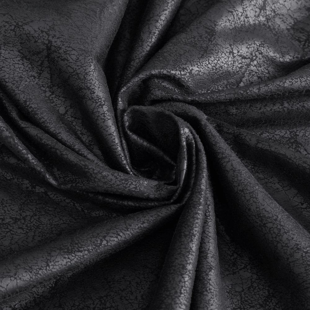 Close-up of black faux leather fabric with a textured, glossy finish, ideal for gothic fashion pieces.
