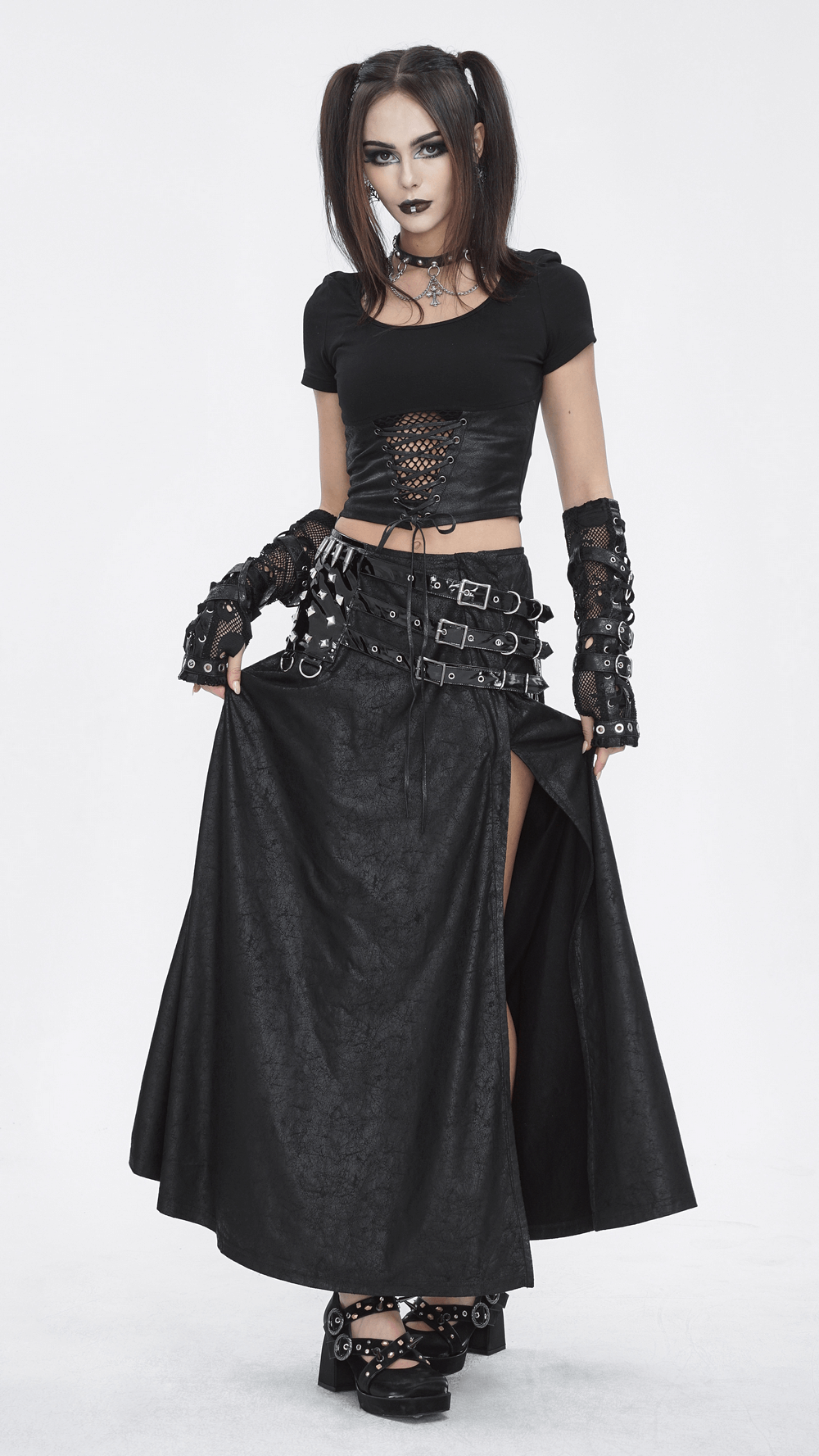Gothic model wearing a chic black faux leather long skirt with buckles and slit, paired with a crop top and edgy accessories.