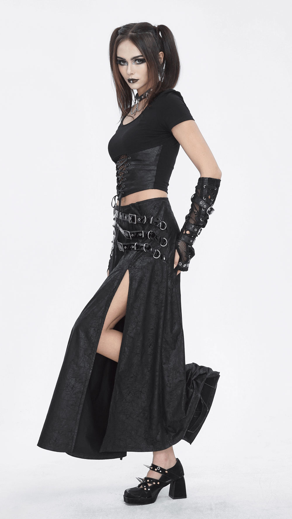 Chic black faux leather buckled long skirt with a high slit, styled for a gothic look with a fitted top and accessories.