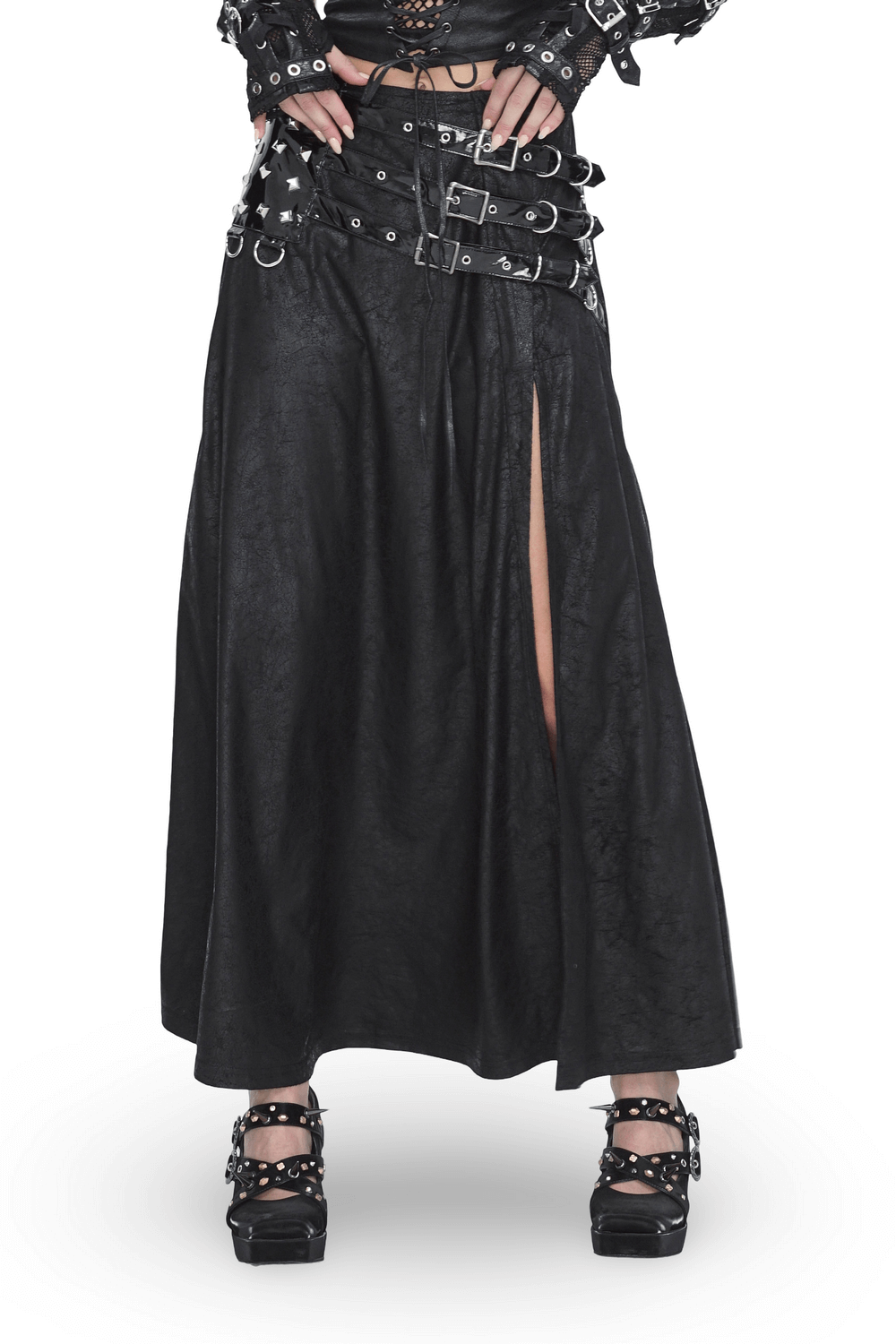 Chic black faux leather long skirt with buckles and a slit for a gothic look, styled with chunky heeled boots.