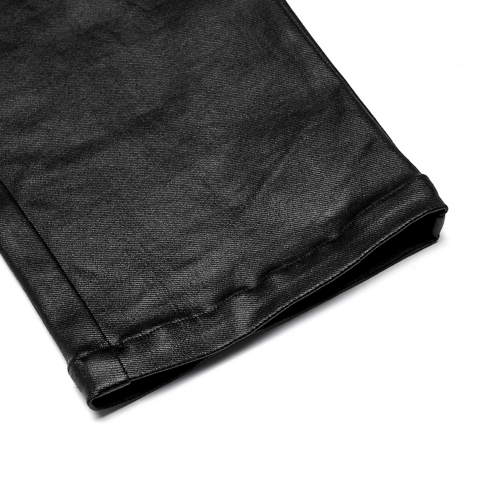 Close-up of the hem of chic black faux leather zippered skinny pants showcasing sleek texture and stylish finish.