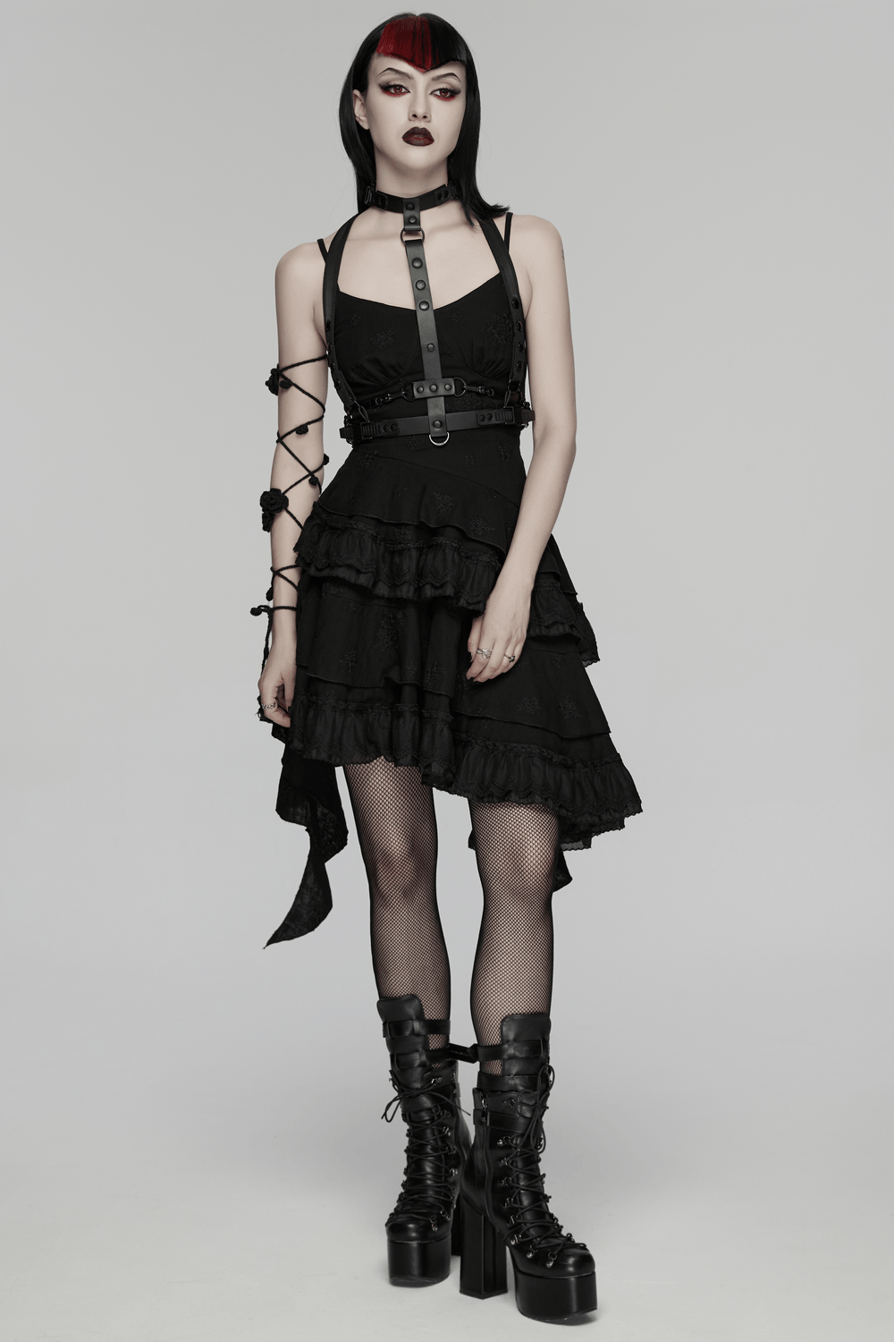 Alt Tag: Chic Black Gothic Asymmetrical Lace Ruffle Slip Dress on model, black embroidered goth slip with ruffle hem, harness belt, platform boots