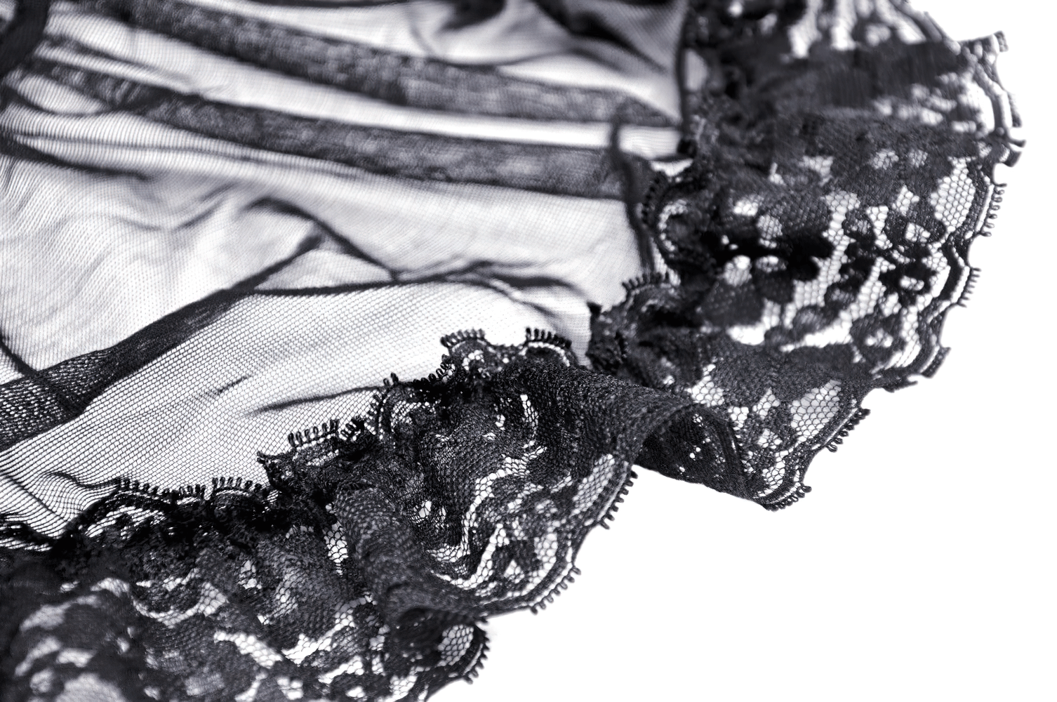 Close-up of black lace and sheer mesh fabric with ruffled edges, perfect for elegant gothic fashion.