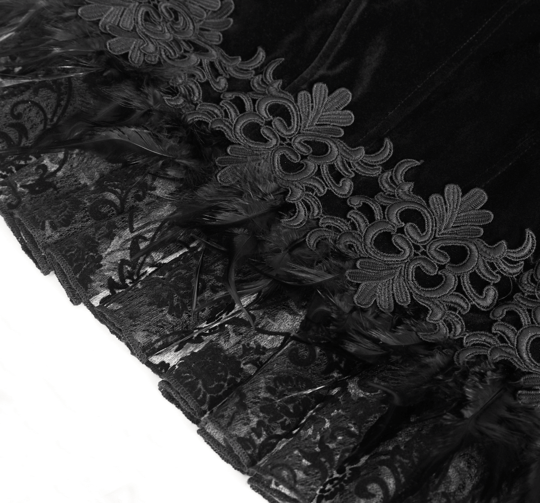 Close-up of chic black lace bolero featuring intricate floral embroidery and feathered trim, showcasing gothic elegance.