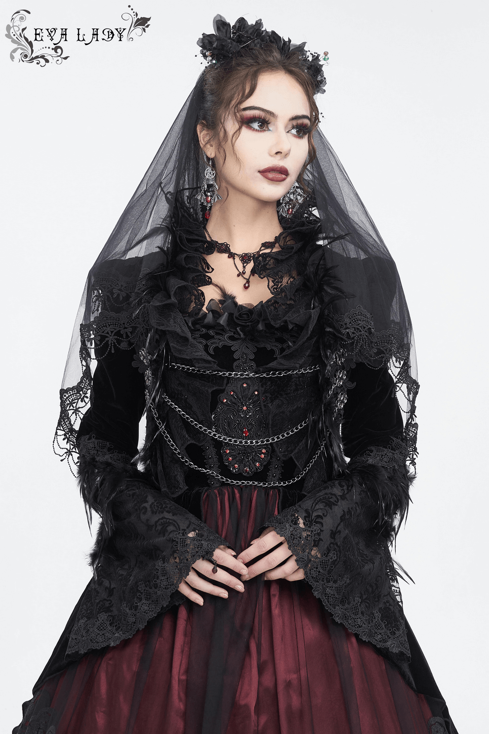 Gothic model wearing a chic black lace bolero with feathers and chain accents, exuding elegance and drama.