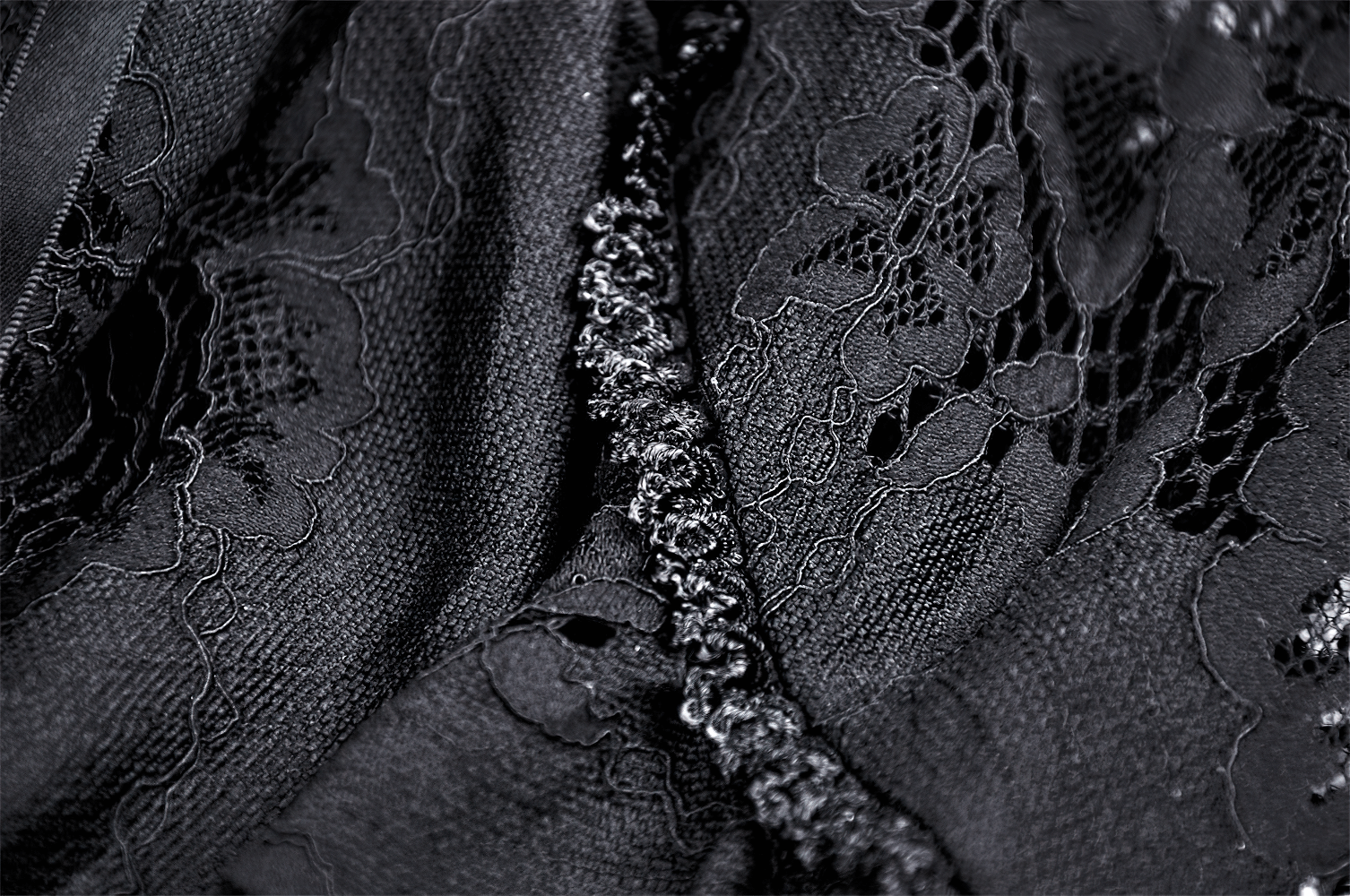 Close-up of black lace fabric featuring elegant floral patterns and ruffled details for a chic mermaid skirt.