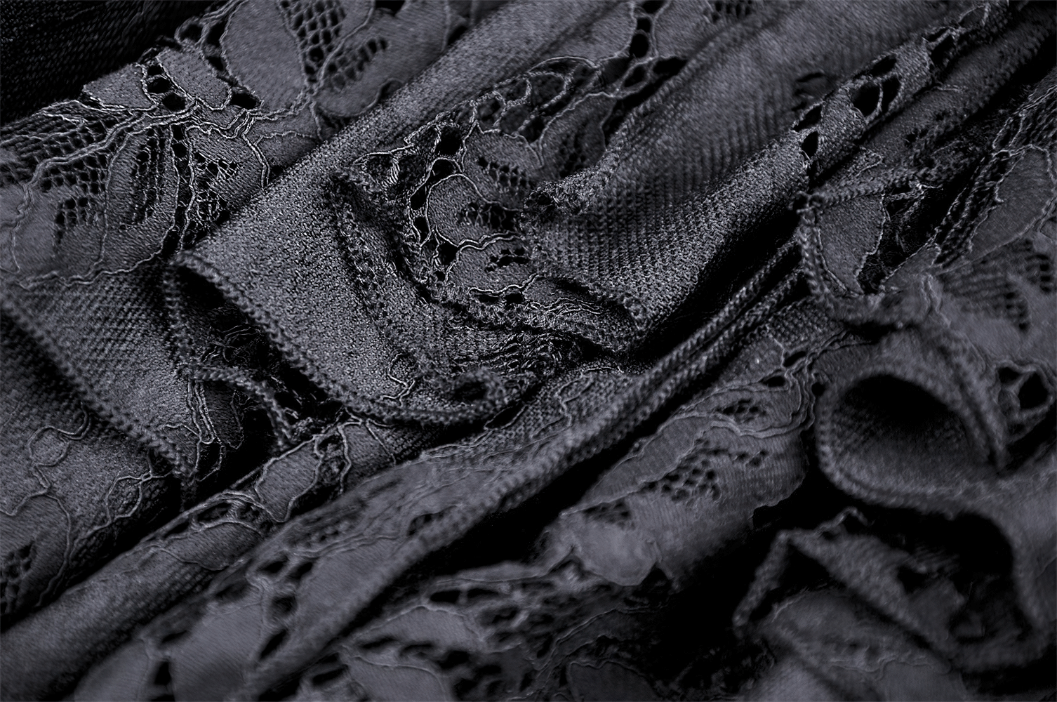 Close-up of elegant black lace fabric showcasing intricate details and layered ruffles for a gothic mermaid skirt.