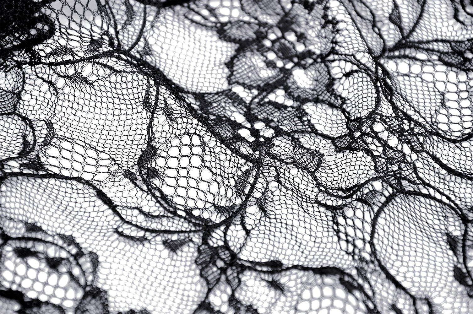 Close-up of intricate black lace fabric, showcasing delicate floral patterns perfect for a gothic mermaid skirt.