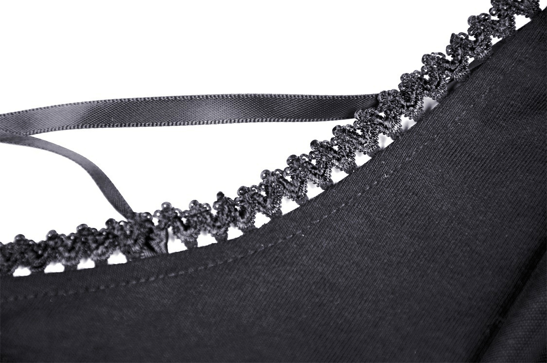 Close-up of black lace trim and satin tie detail on a chic mini dress, showcasing elegant design and sophisticated style.