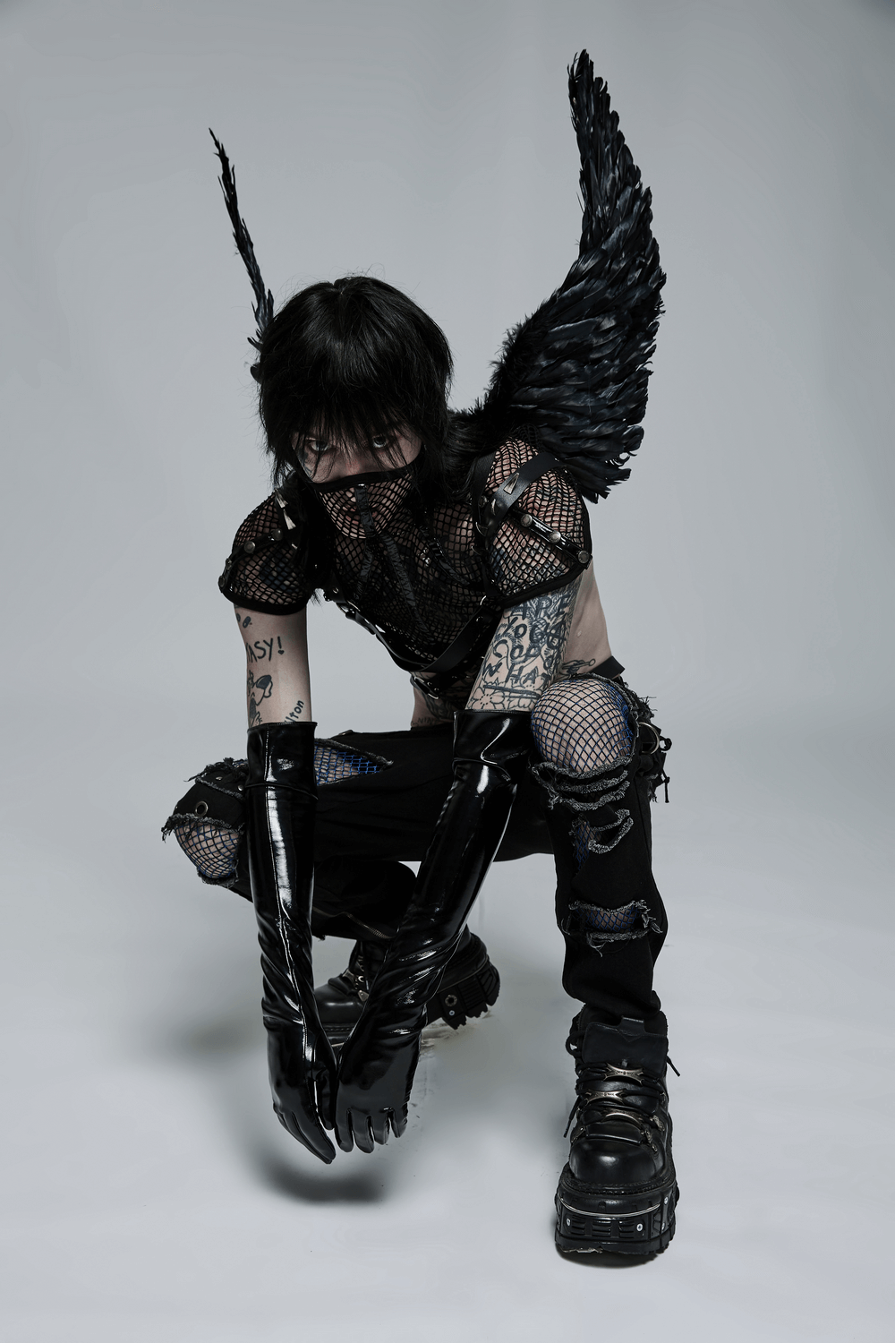 Chic black mesh statement mask collar with shoulder pads, edgy style in a fashion-forward urban outfit.