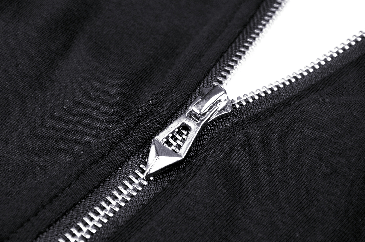 Close-up of a silver zipper on a black fabric, showcasing quality craftsmanship and stylish design.