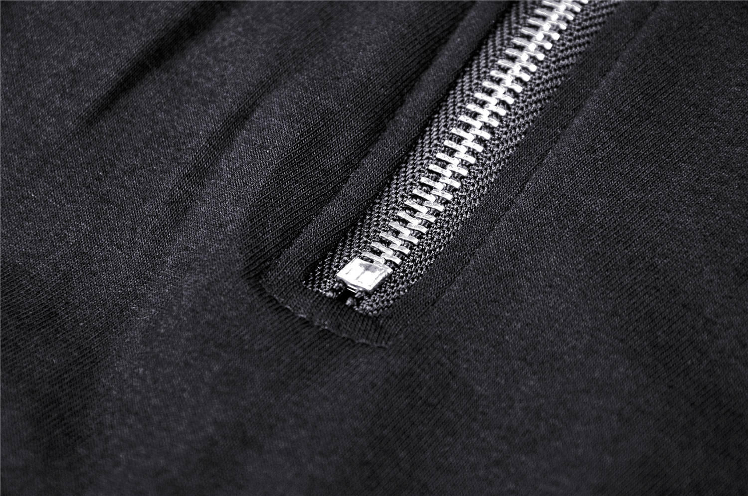 Close-up of a stylish black fabric featuring a metal zipper detail, showcasing modern fashion design.