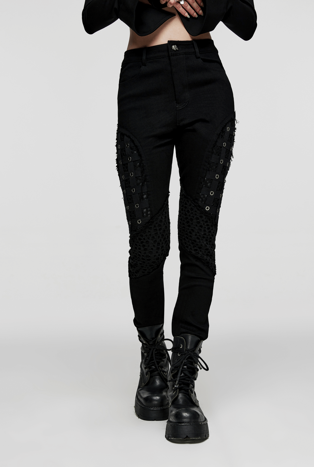 Chic black rubberized mesh punk skinny pants for women with geometric eyelets, embodying gothic style.