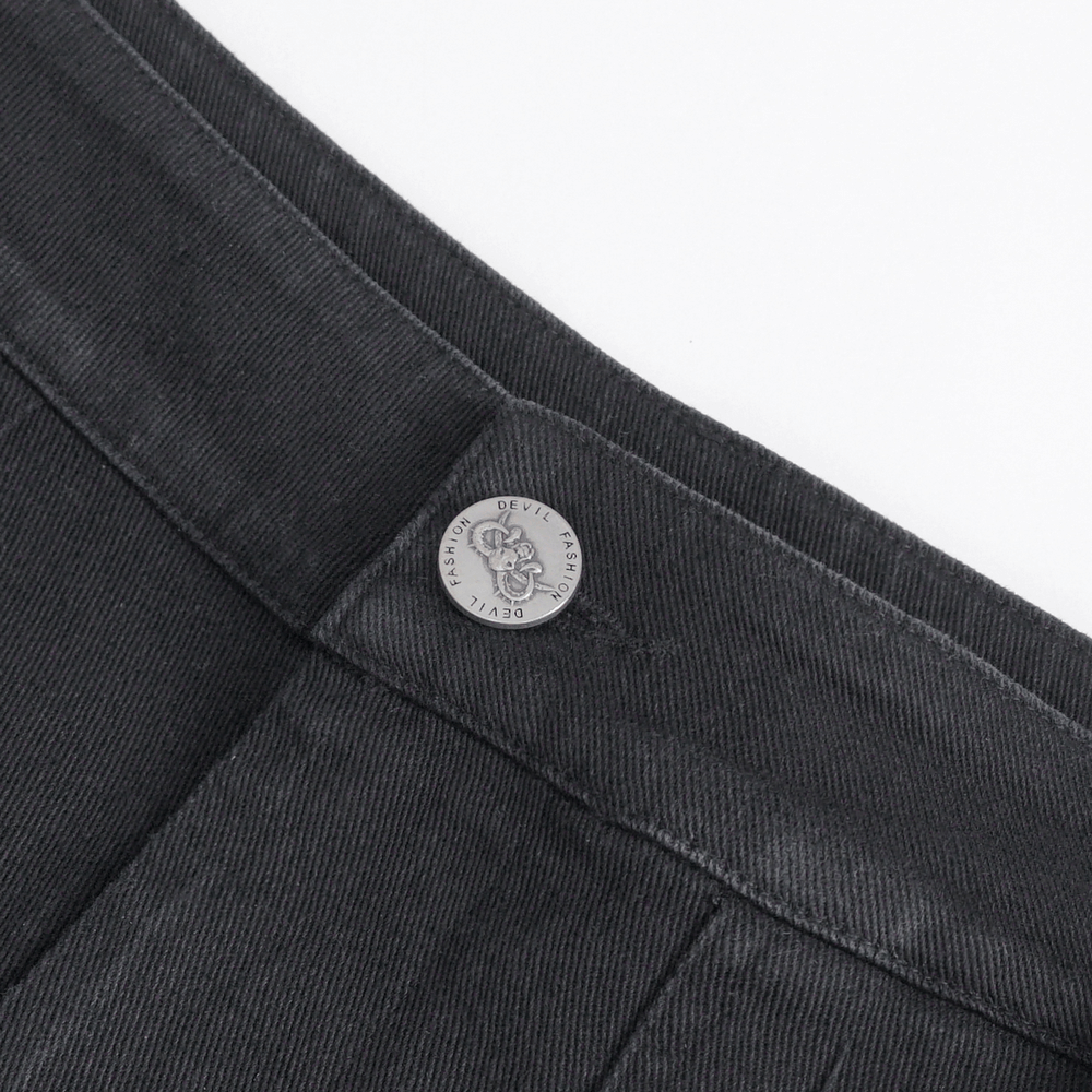 Close-up of chic black studded jeans showing buckle detail and stylish waistband.