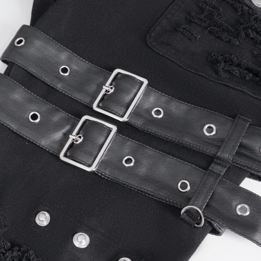 Close-up of black studded ripped jeans with buckle details and stylish hardware accents.
