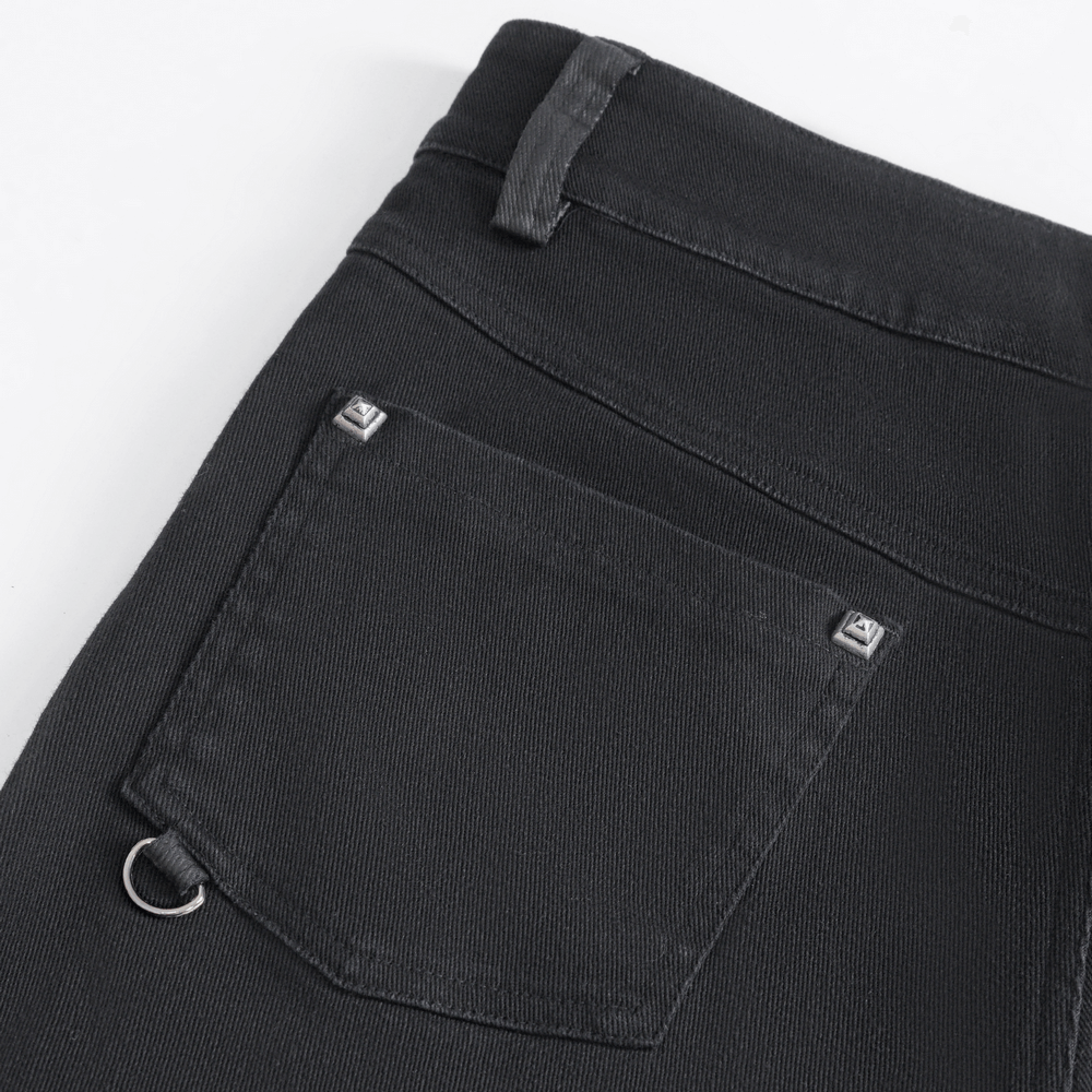 Close-up of chic black studded ripped jeans featuring buckle details and a stylish back pocket.