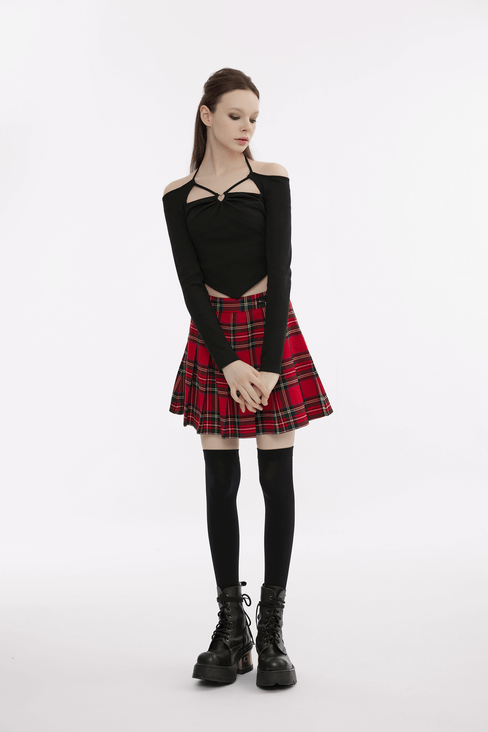 Chic black off-the-shoulder top paired with a red plaid skirt, creating a trendy Gothic fashion look.