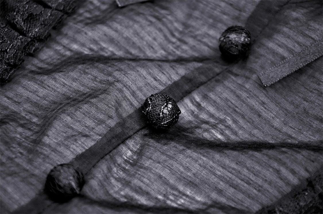 Close-up of delicate black lace fabric featuring elegant buttons and ruffled texture, perfect for gothic-style fashion.