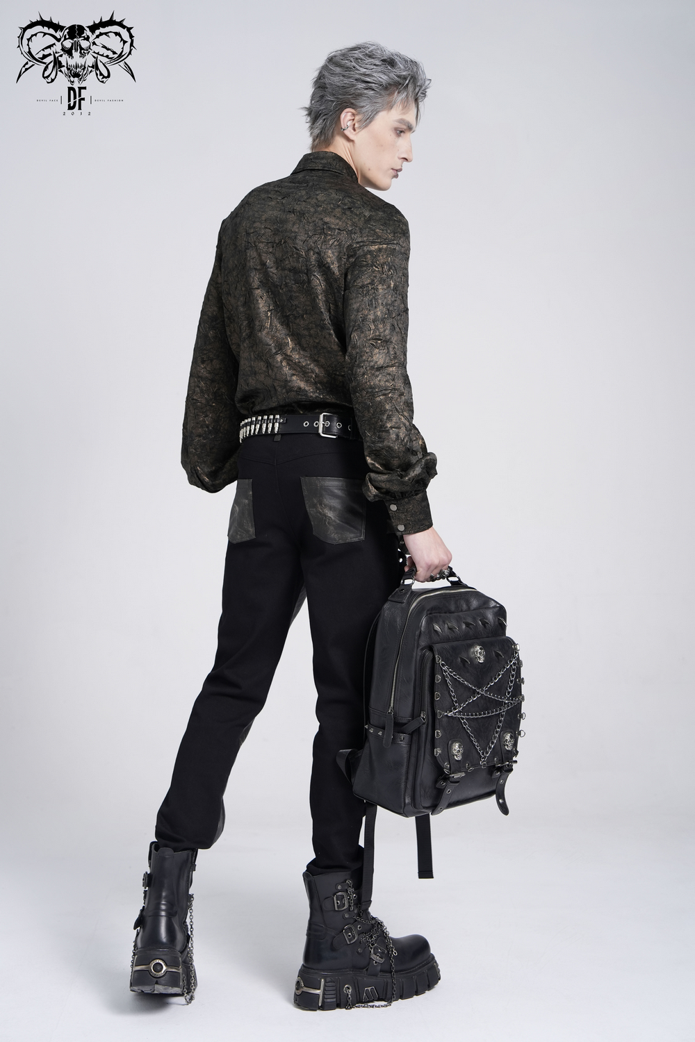 Stylish model in chic chain shirt with faux leather straps and loops, showcasing punk rock streetwear vibe.