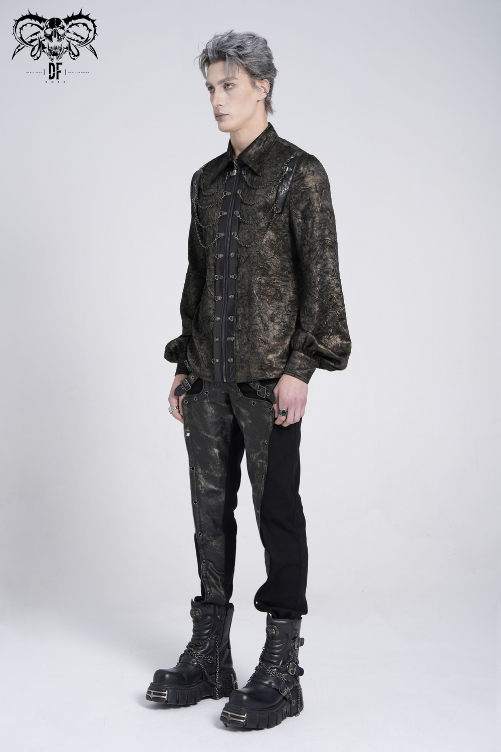 Chic punk rock shirt with faux leather straps and chains, styled with black pants and bold boots.