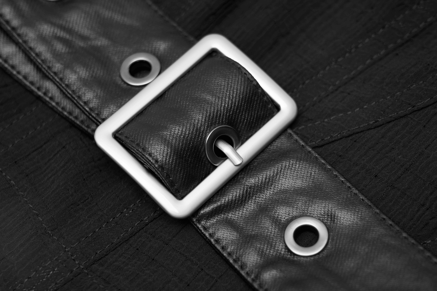 Close-up of a stylish black leather belt buckle with silver detailing, perfect for enhancing chic outfits.